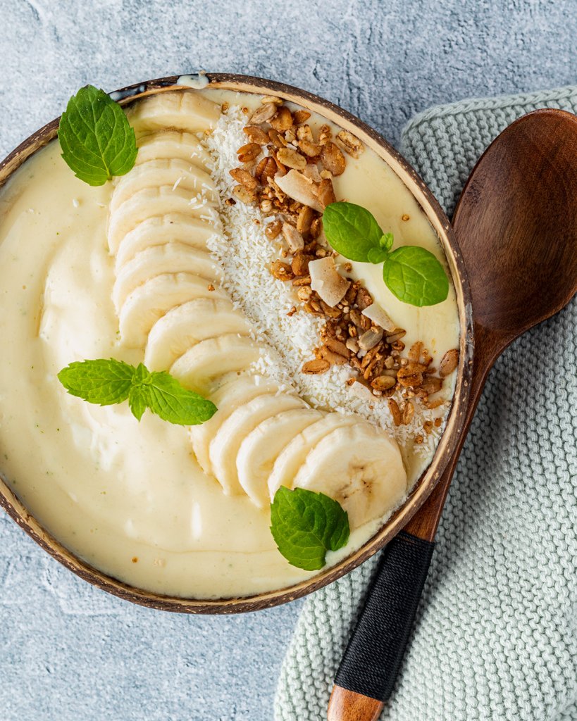 Ananas Smoothie Bowl mit Banane, Granola, Kokosraspeln und Minzbl&auml;tter