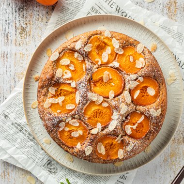 Aprikosenkuchen mit Aprikosenh&auml;lften, Mandelbl&auml;ttchen und Puderzucker