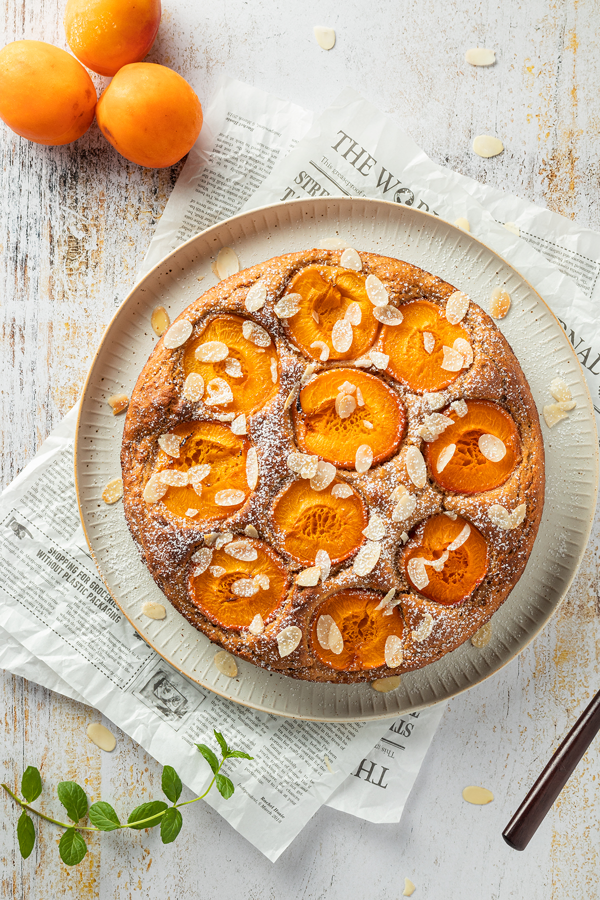 Aprikosenkuchen mit Aprikosenh&auml;lften, Mandelbl&auml;ttchen und Puderzucker