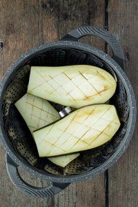 eingeritzte Auberginen-Scheiben in einem Topf mit Dampfgareinsatz