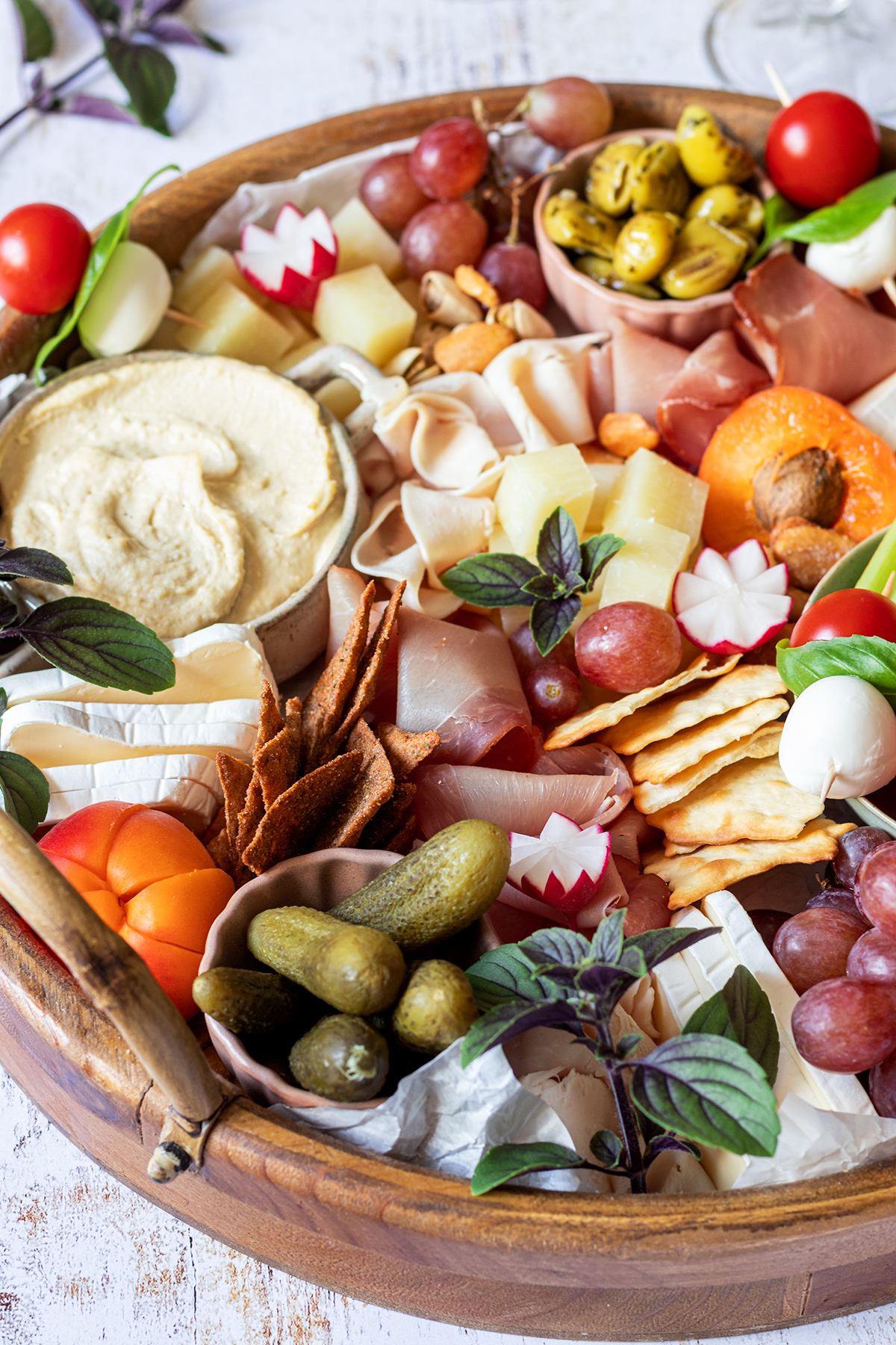 Eine reichlich gef&uuml;llte Brotzeitplatte mit K&auml;se, Schinken, Dips, Gem&uuml;se, Obst und Cracker.