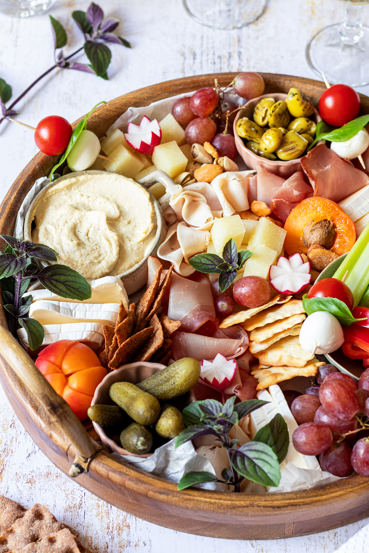 Eine reichlich gef&uuml;llte Brotzeitplatte mit K&auml;se, Schinken, Dips, Gem&uuml;se, Obst und Cracker.