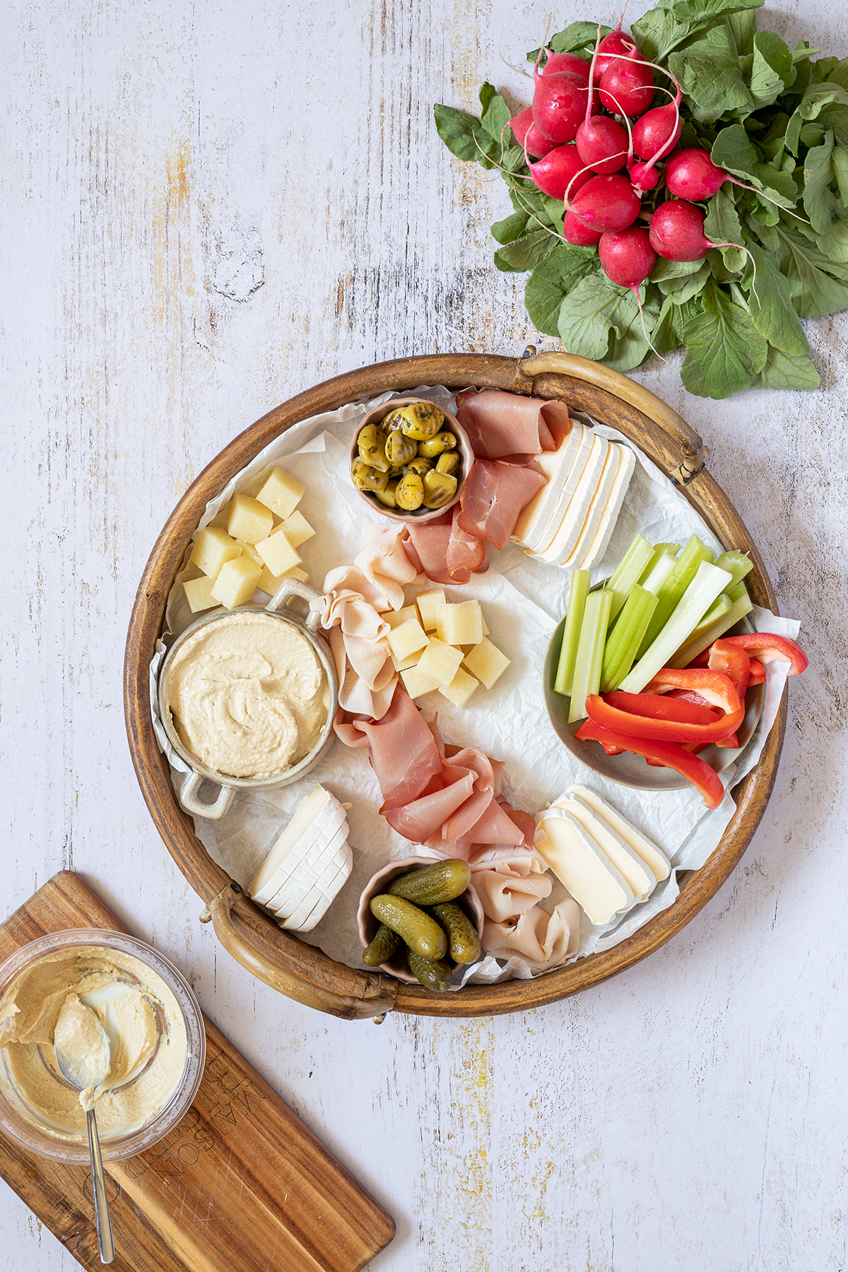 Die Sch&uuml;sseln auf der Brotzeitplatte wurden mit Hummus, Oliven, Essiggurken und Gem&uuml;sesticks gef&uuml;llt.