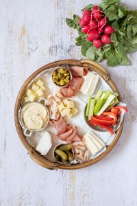 Die Sch&uuml;sseln auf der Brotzeitplatte wurden mit Hummus, Oliven, Essiggurken und Gem&uuml;sesticks gef&uuml;llt.