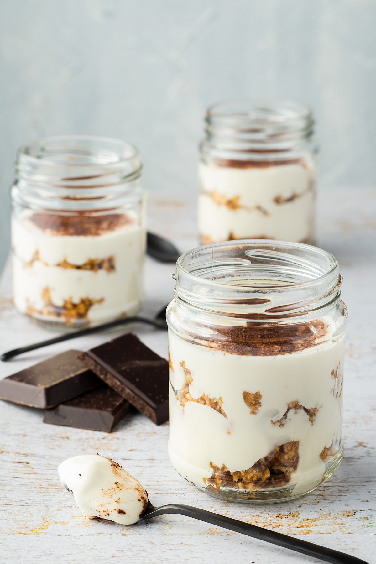drei Portionen der Fitness Tiramisu im Glas auf einem wei&szlig;en Holztisch