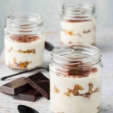 Drei Gläser Fitness Tiramisu auf einem weißen Holztisch