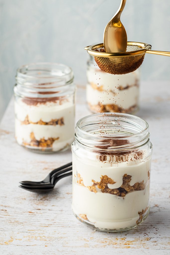 Die Fitness Tiramisu Bowl wird mit Kakao Pulver bestäubt