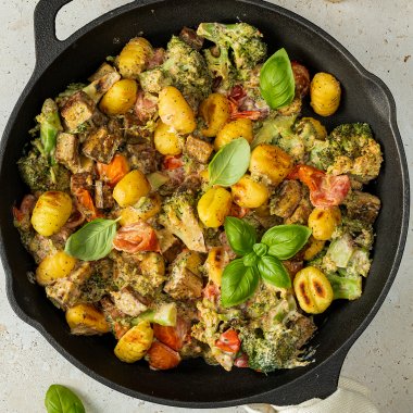 Gusseisenpfanne mit einer schnellen Gnocchi Pfanne mit Pesto-Frischkäse-Soße, Tomaten, Brokkoli und frischen Basilikum