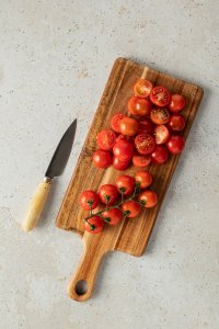 Tomaten werden auf einem Holzbrett halbiert