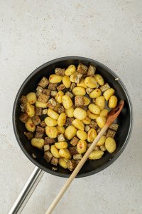 angebratene Tofu-Würfeln und Gnocchi in einer Pfanne