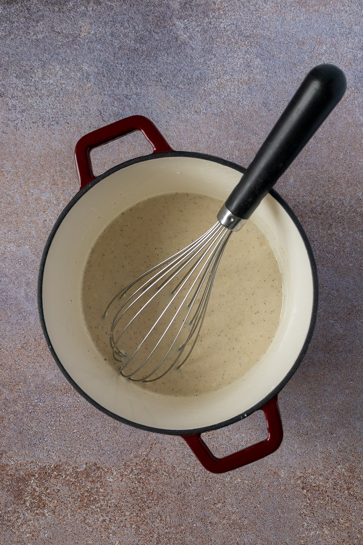 Vanille Proteinpudding wird in einem Topf zubereitet.