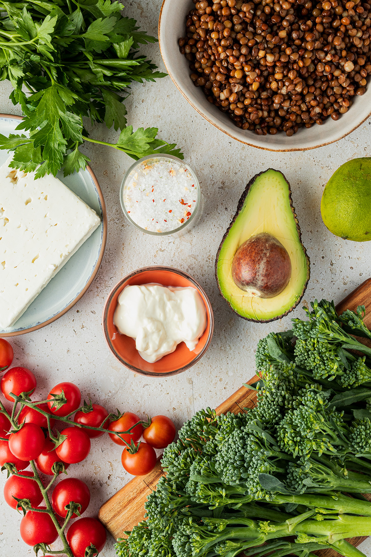 Zutaten für den Linsensalat mit Feta: braune Linsen, Petersilie, Brokkoli, Feta, Tomaten, Avocado, Joghurt, Salz und Limette