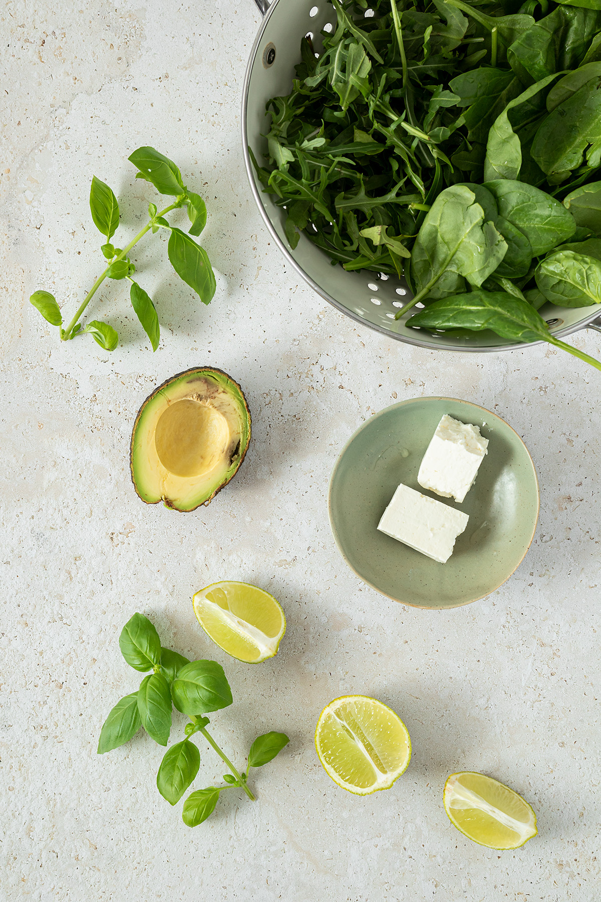 Zutaten f&uuml;r die Avocado Feta Pesto: Spinat, Rucola, Basilikum, eine halbe Avocado, Limettenspalten und Feta