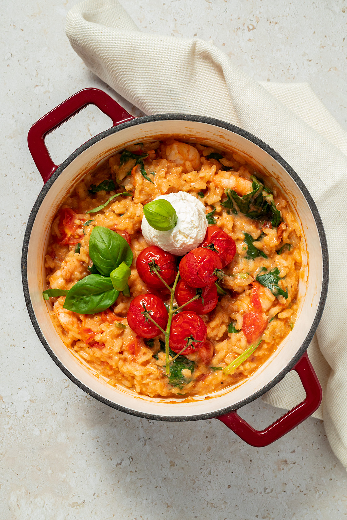 Ofenrisotto mit Tomaten, Ricotta, Spinat und Garnelen in einem Schmortopf serviert