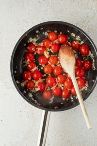 angebratene Schalotten- und Knoblauchw&uuml;rfel und halbierte Cherrytomaten