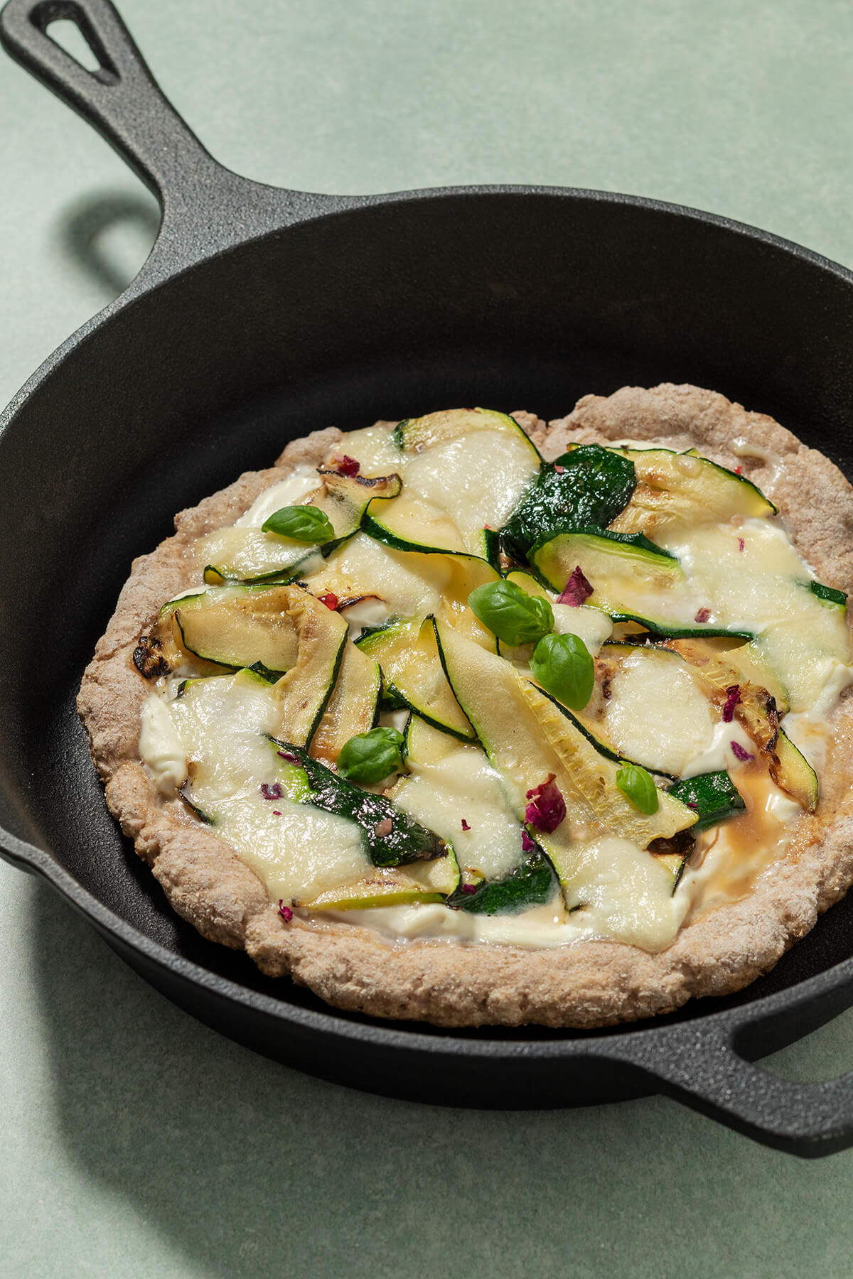 Gebackene Pfannenpizza mit Gem&uuml;sebelag in einer Pfanne.