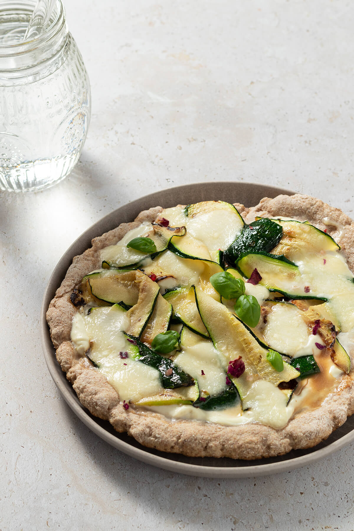 einfache Pfannenpizza belegt mit Ricotta, Zucchini und K&auml;se