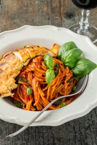 Hähnchenbrust Piccata Milanese serviert mit einfachen One Pot Spaghetti und einem Glas Rotwein