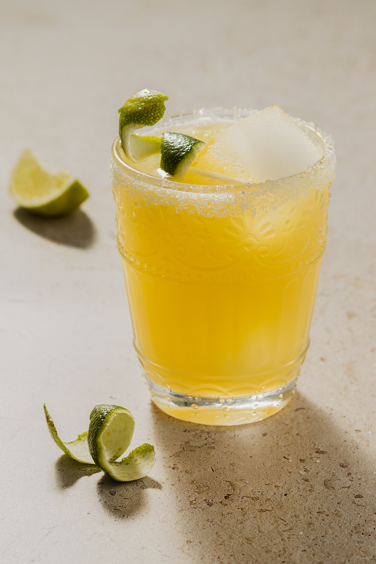 Das Bild zeigt den Skinny Margarita Cocktail, einen kalorienarmen Cocktail mit Tequila, Orangen- und Limettensaft, serviert mit einer Limettenschale