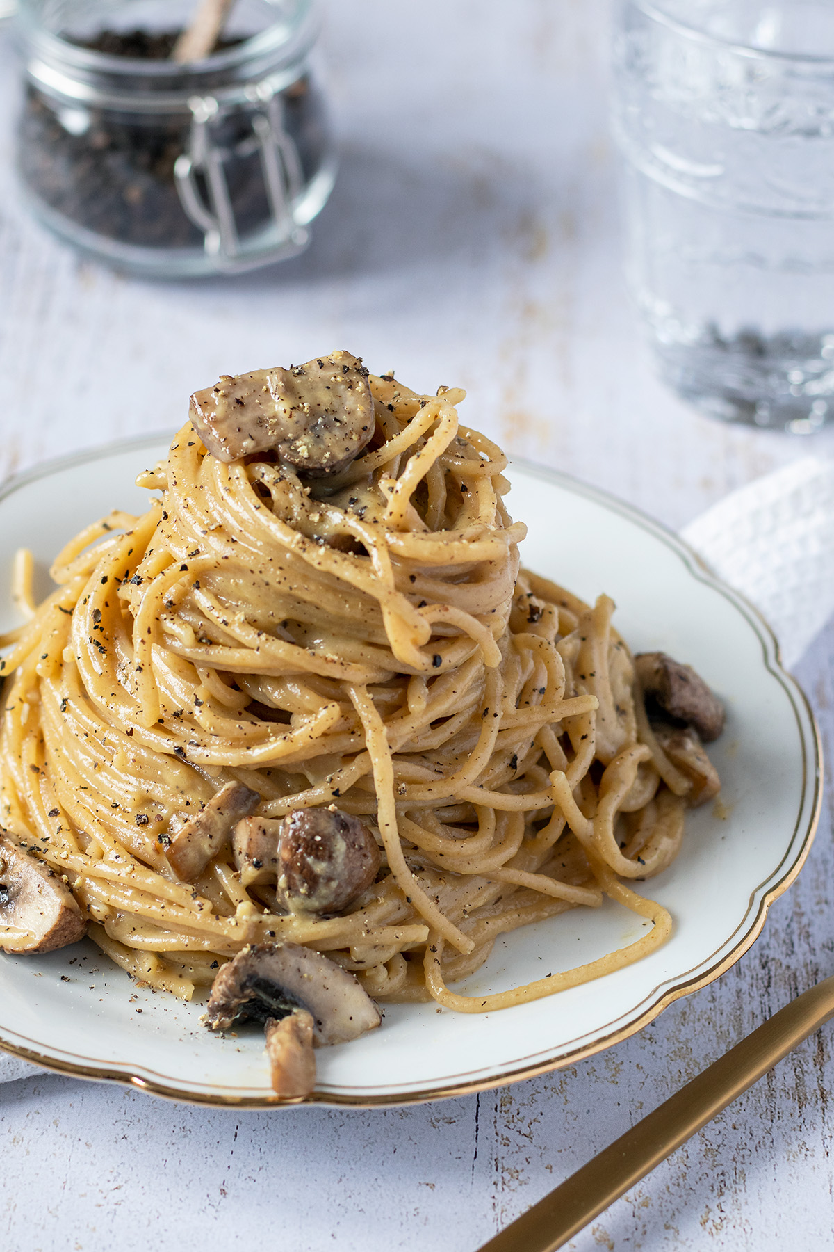 Eine Portion an cremigen Spaghetti carbonara mit Champignons und frischen Pfeffer.
