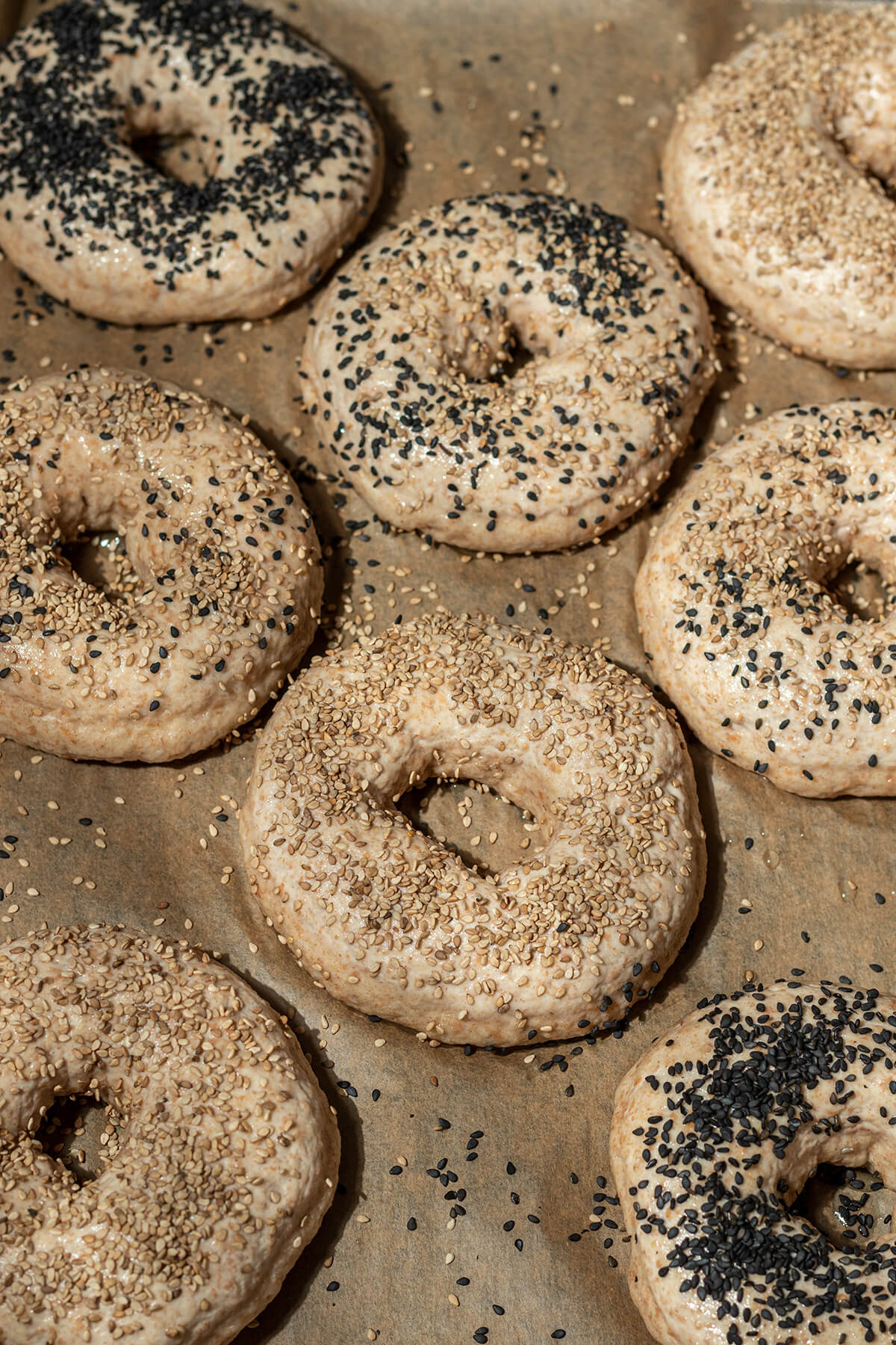 Bagels mit Eiklar bestrichen und mit Mohn und Sesam bestreut.