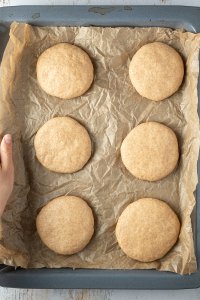 Teig f&uuml;r die Vollkorn Burger Br&ouml;tchen in sechs gleichgro&szlig;e Patties geformt auf einem Backblech mit Backpapier