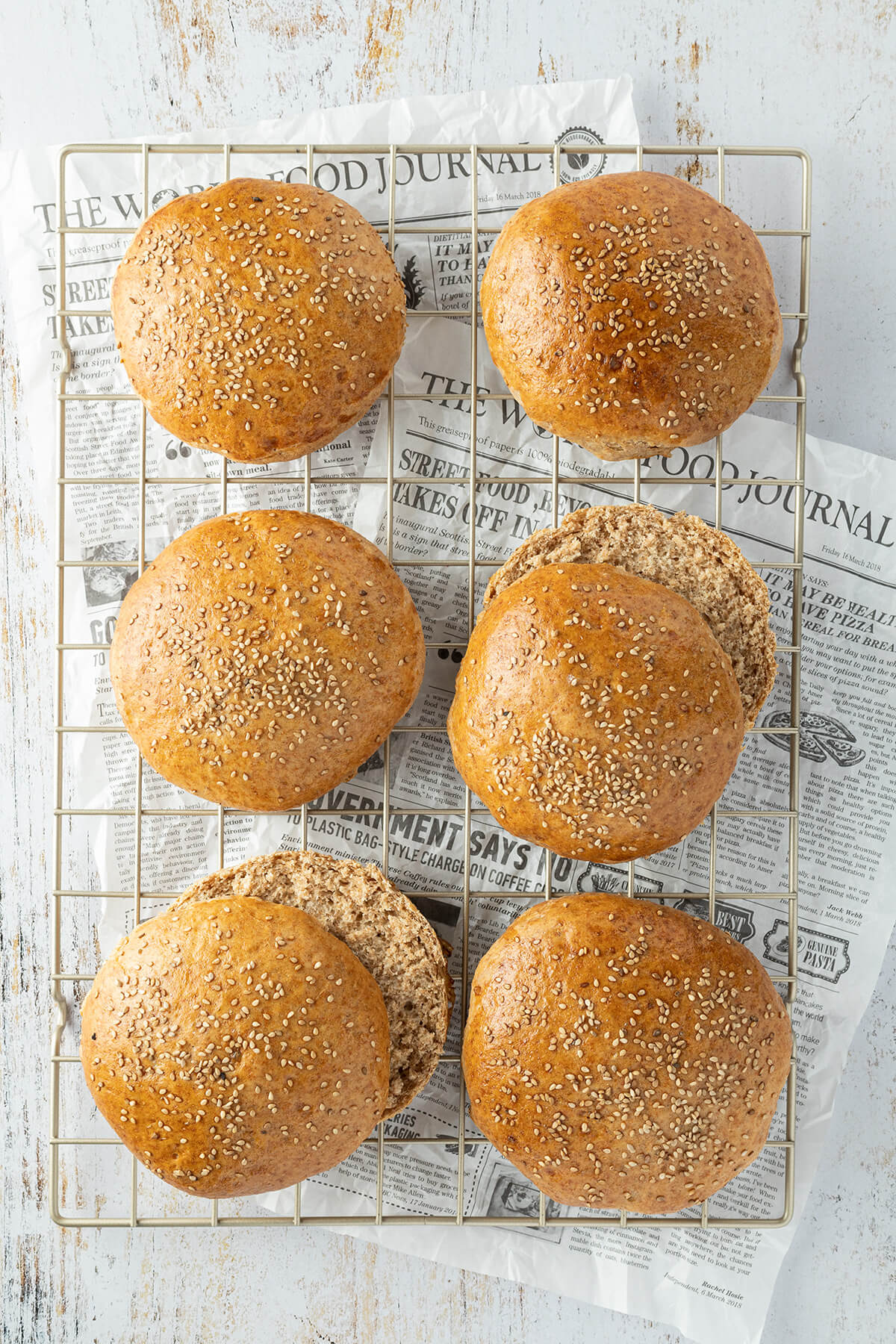 Sechs Vollkorn Burger Br&ouml;tchen auf einem Abk&uuml;hlgitter.