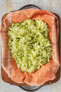 Geraspelte Zucchini auf einem Geschirrtuch.