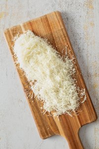 Geriebener K&auml;se auf einem Holzbrett.