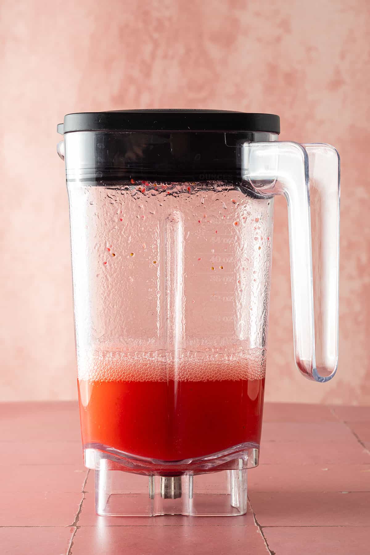 Gemixert, d&uuml;nnfl&uuml;ssiger, rote Drink in einem Mixbeh&auml;lter.