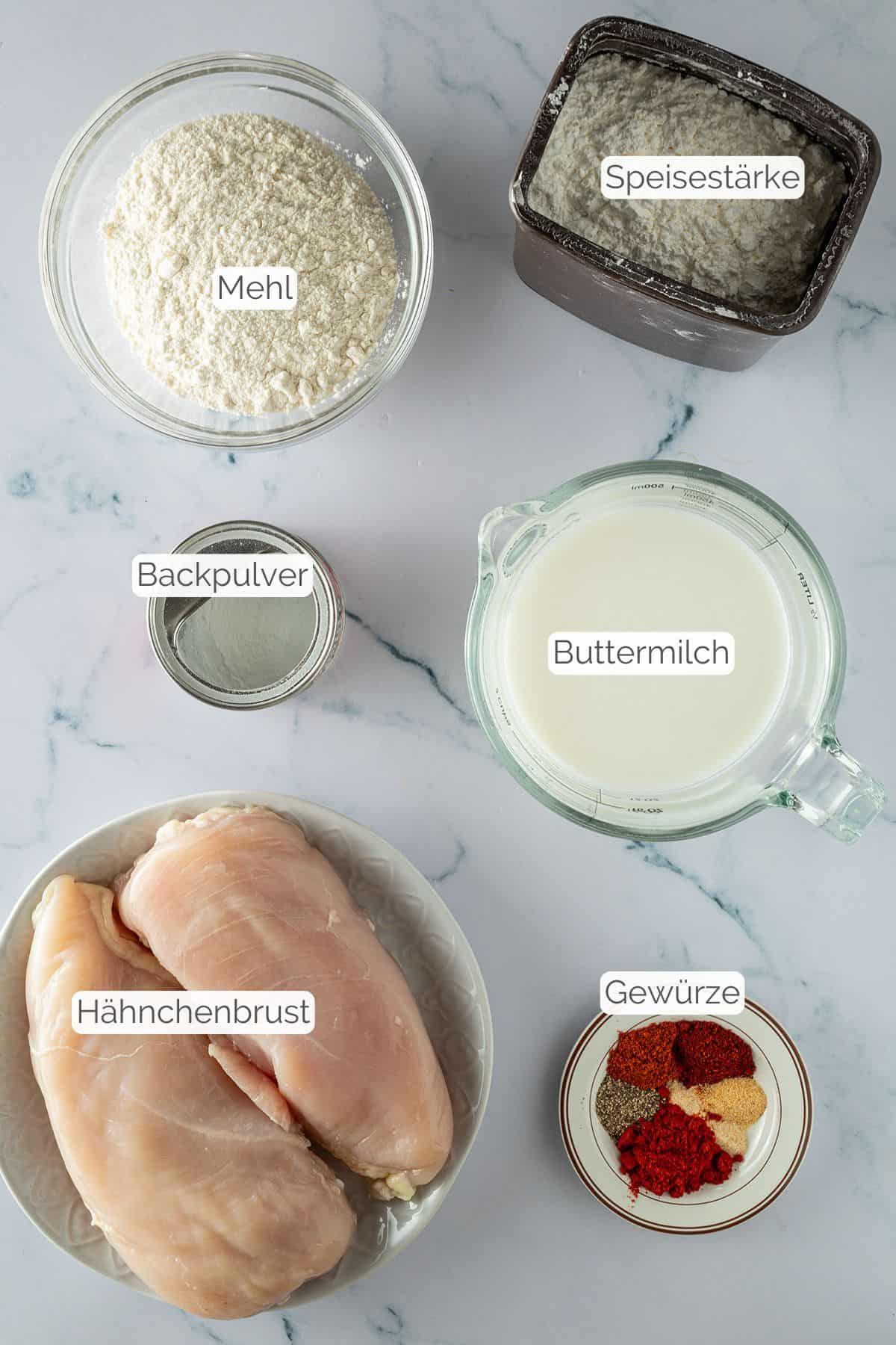 Alle Zutaten mit jeweiligen Textbeschriftungen, die f&uuml;r Fried Chicken aus dem Airfryer ben&ouml;tigt werden.