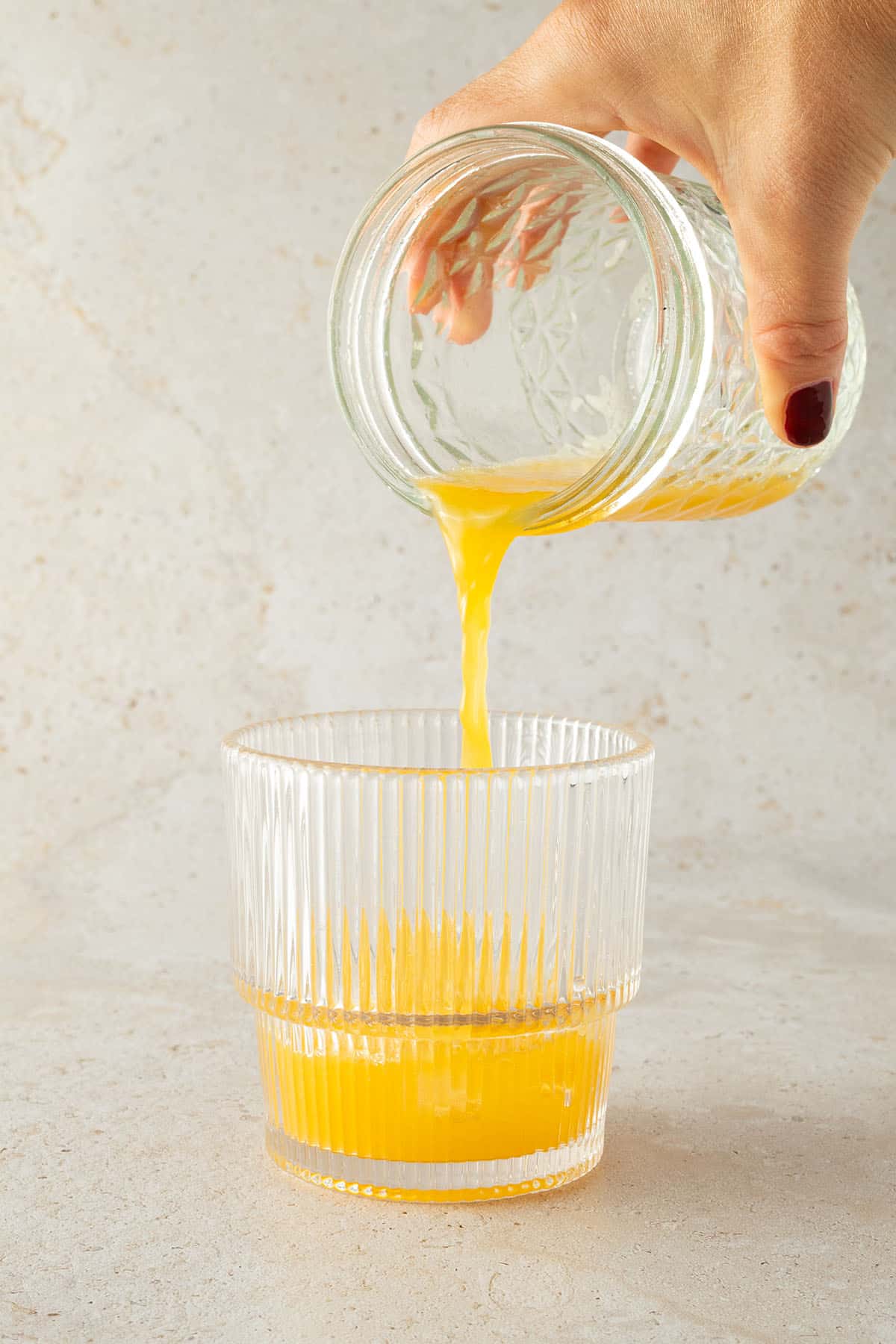 Organen-Limettensaft wird in ein Glas gegossen.