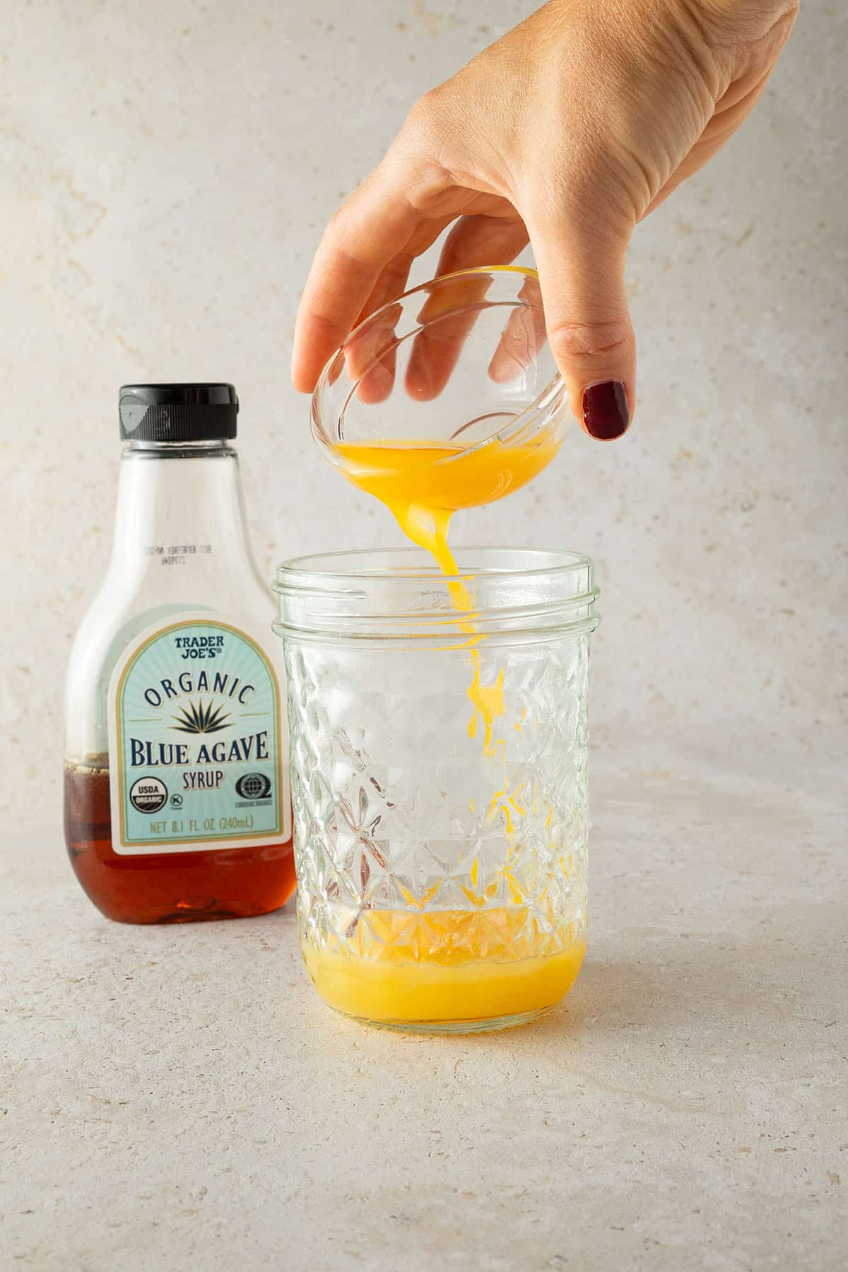 Orangensaft wird in das Schraubglas gesch&uuml;ttet.