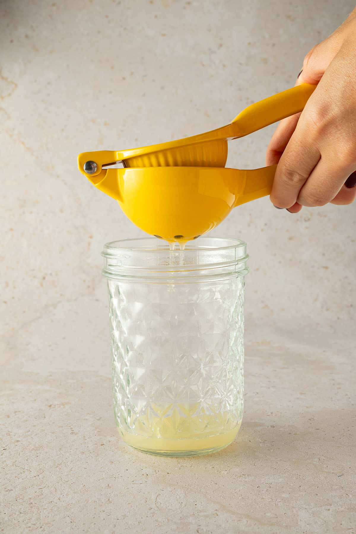 Limettensaft wird in ein Schraubglas ausgepresst.