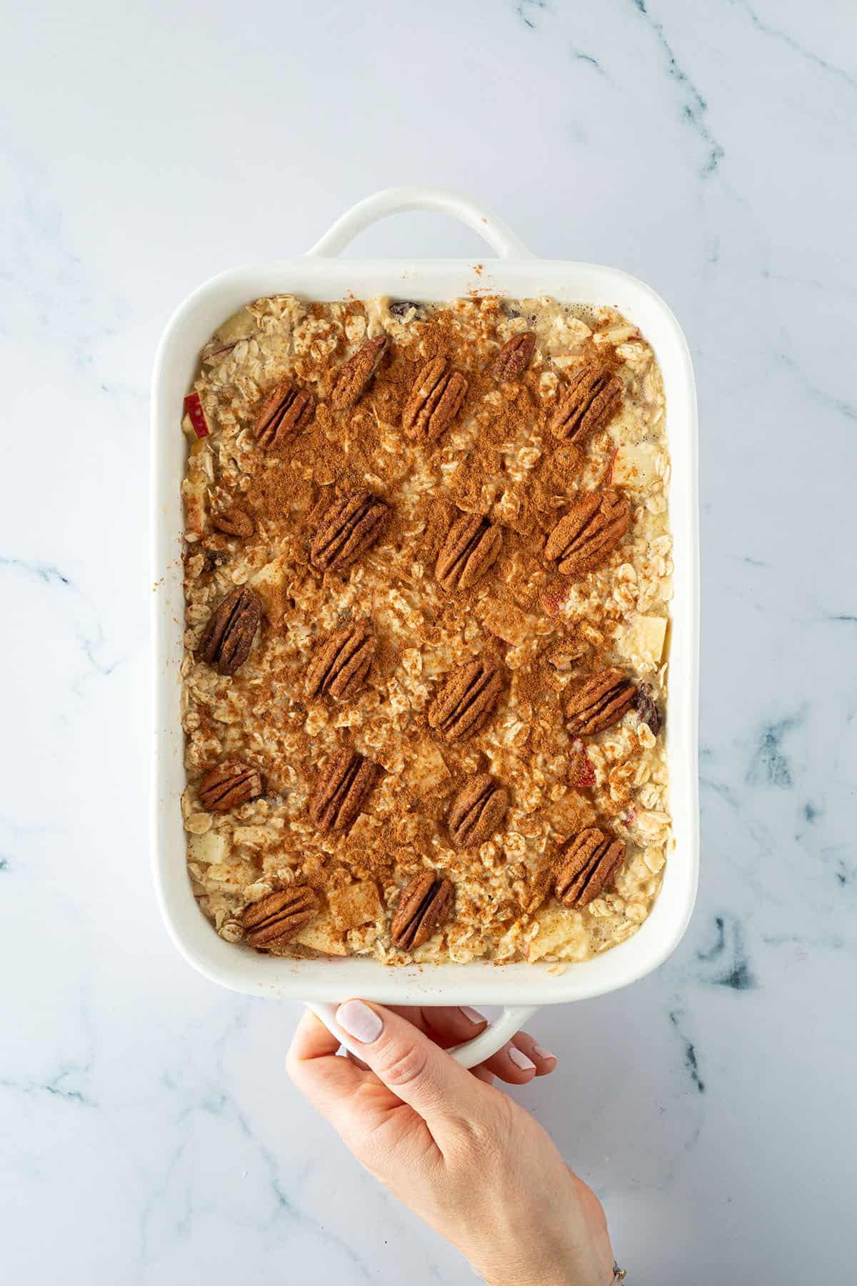 Apfel Baked Oatmeal in einer Auflaufform vorm Backen im Ofen.