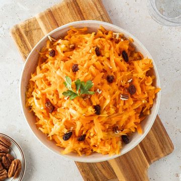 Möhren-Apfel-Salat in einer Schlüssel mit Deko im Bildrand.