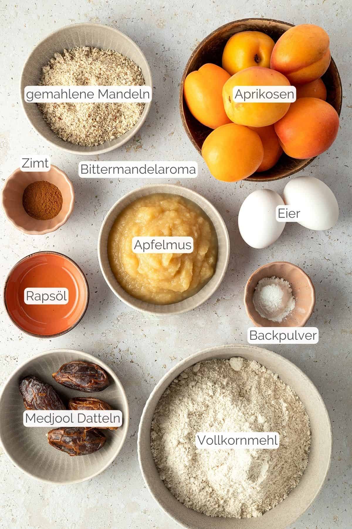 Alle Zutaten mit Textbeschriftungen, die f&uuml;r den Aprikosenkuchen ben&ouml;tigt werden.