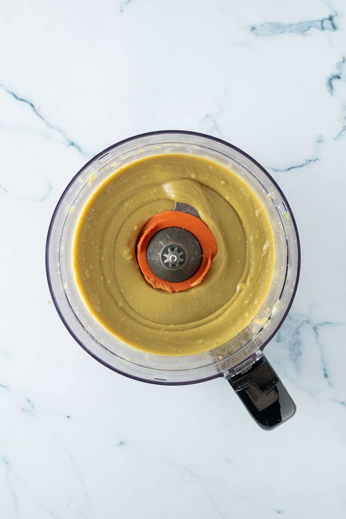 Glatt p&uuml;rierte gr&uuml;ne Avocado-Erdnuss-Creme in einem Mixer.