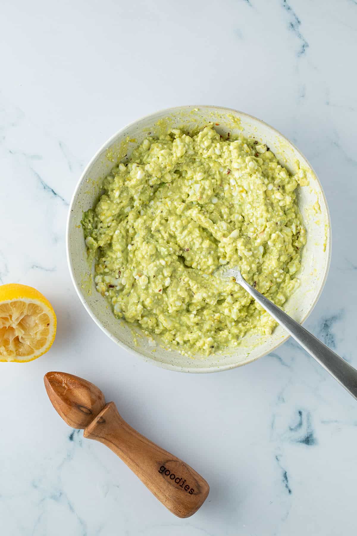 Avocado Eier Creme in einem Teller, daneben eine ausgepresste Zitronenh&auml;lfte.