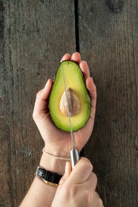 Kern wird mit einem Messer aus der Avocado entfernt.