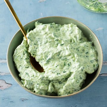 Sch&uuml;ssel mit B&auml;rlauchfrischk&auml;se auf einem blau gestrichenem Holzuntergrund.