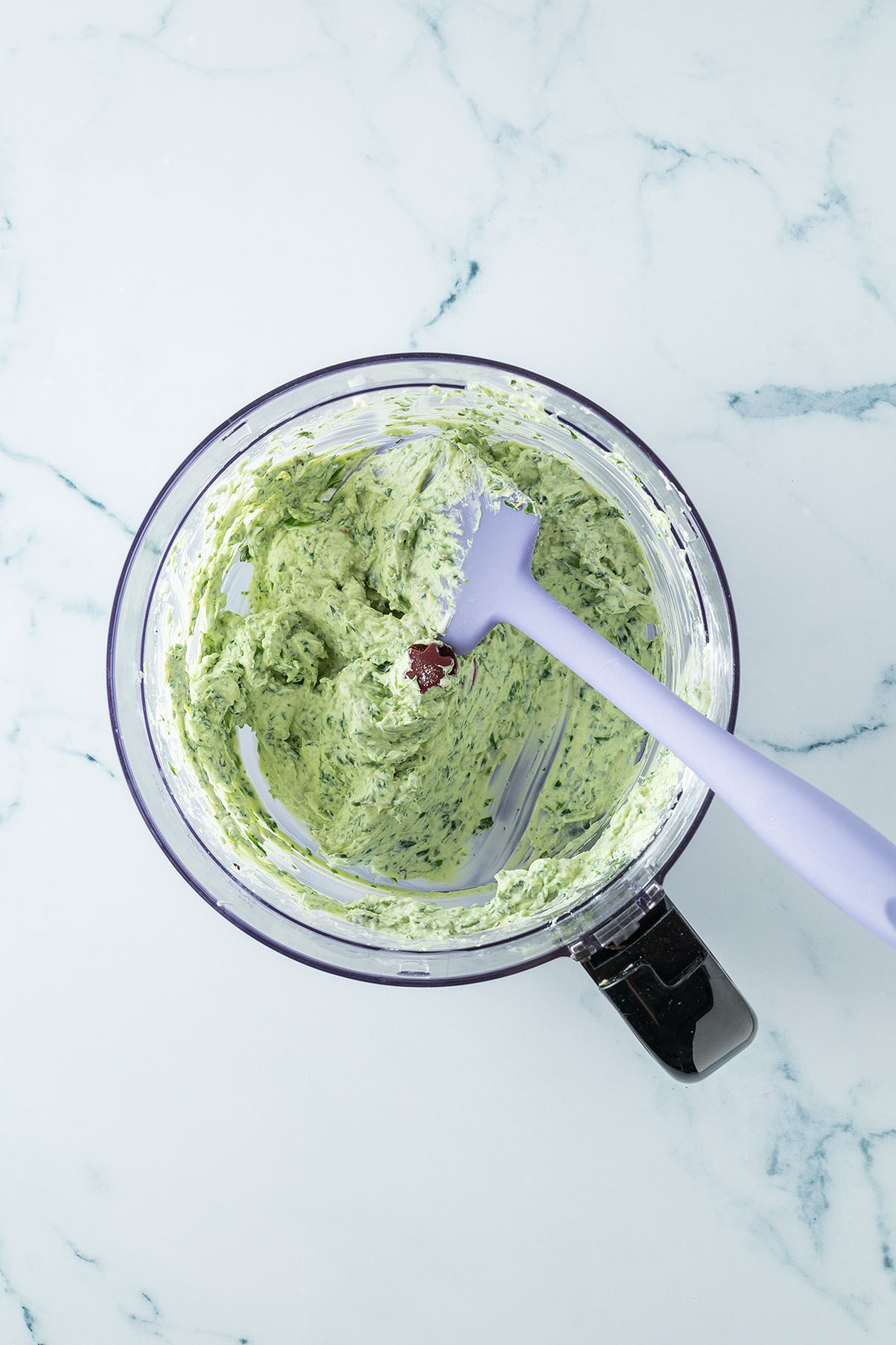 Vogelperspektive auf einen Food Processor in dem ein hellgr&uuml;ner Frischk&auml;se Dip ist.