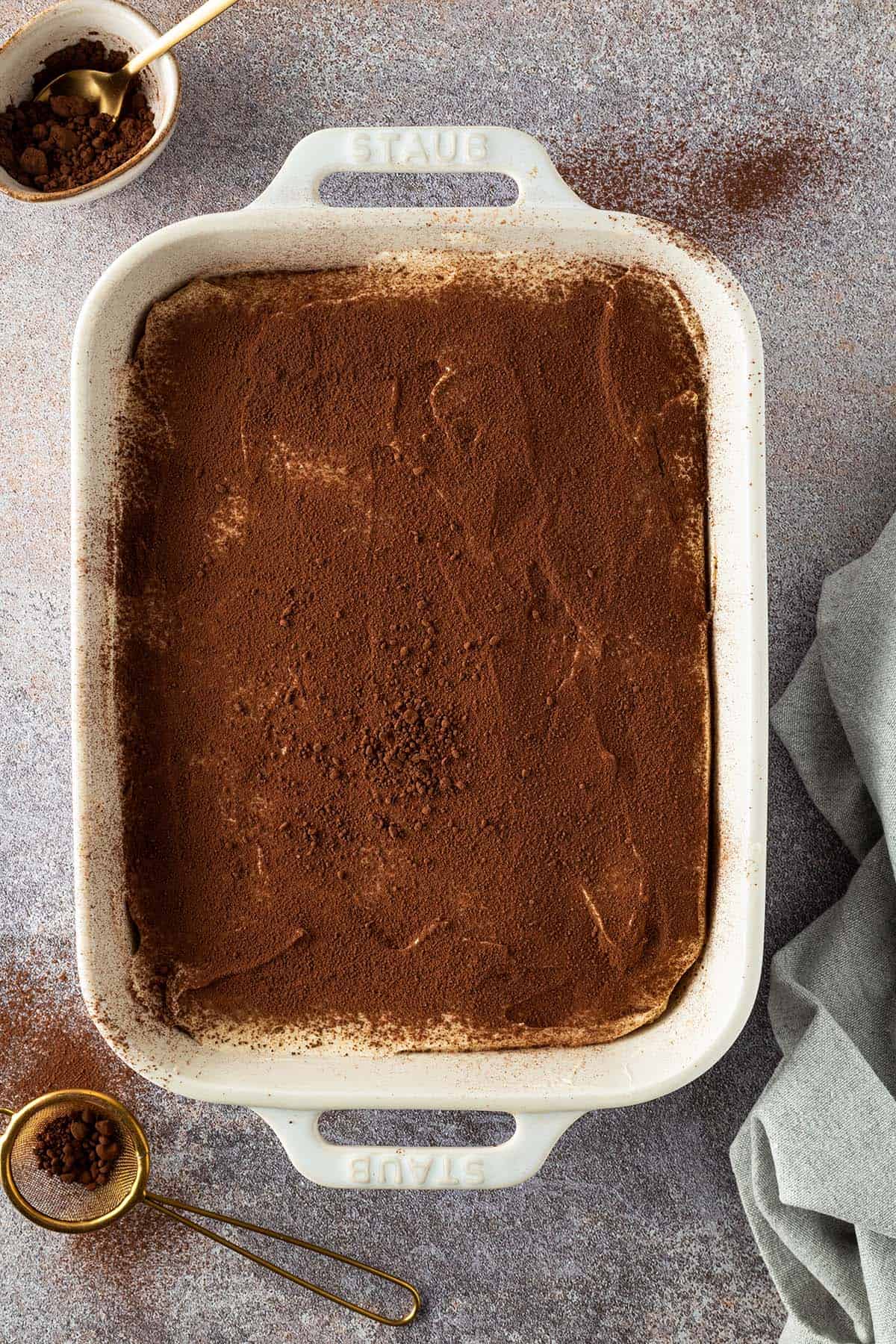 Die fertige, mit Kakao bestreute Tiramisu in einer wei&szlig;en Auflaufform.