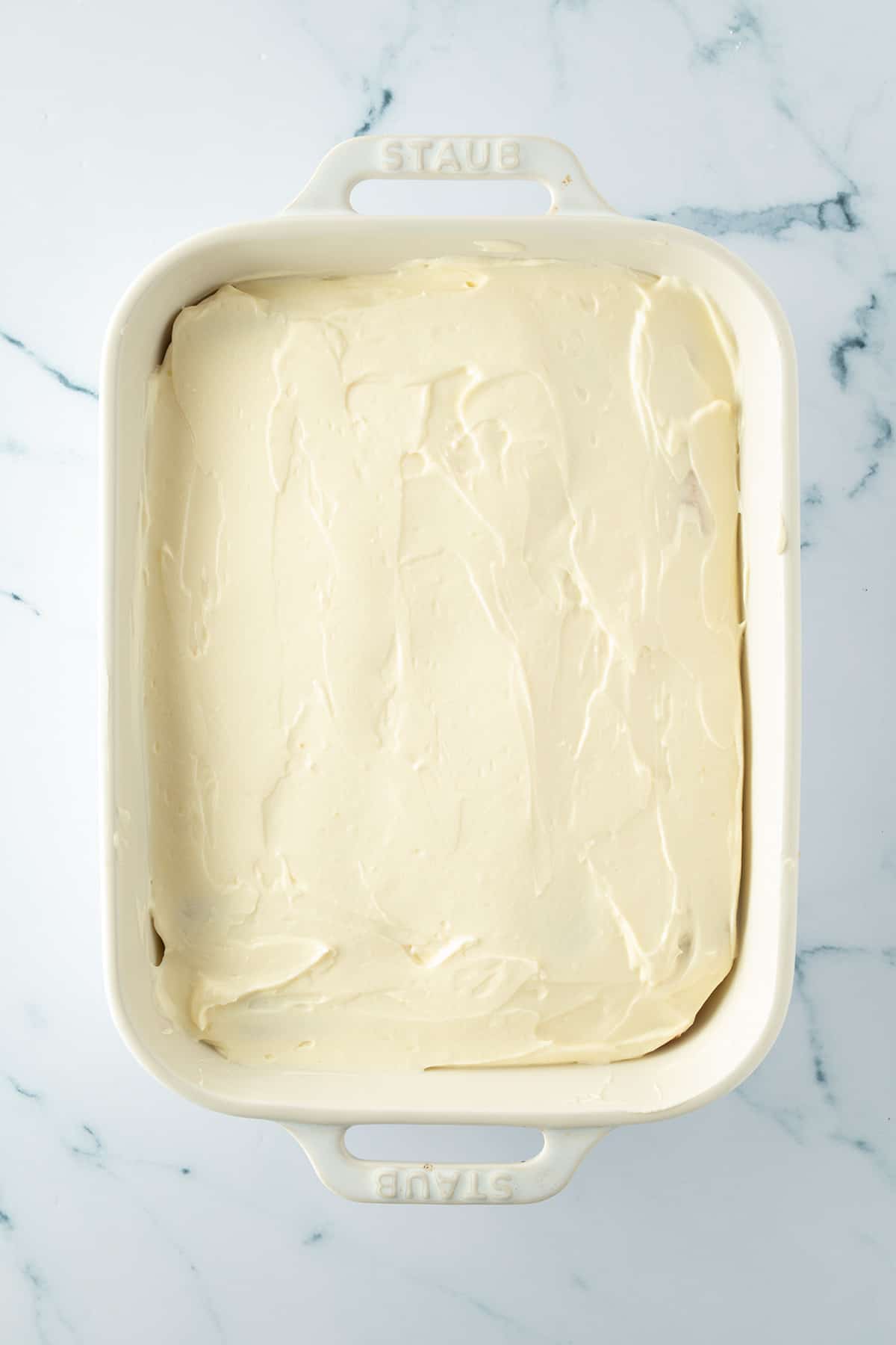 Fertig geschichtete Tiramisu mit einer glatt gestrichenen Mascarpone-Schicht.
