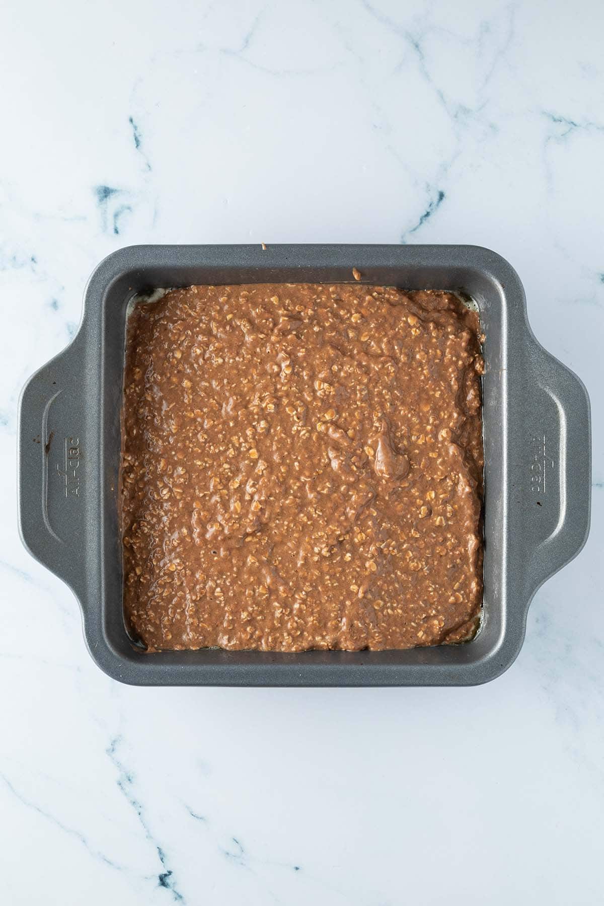 Schokoladiges Baked Oatmeal in einer Auflaufform vorm Backen.