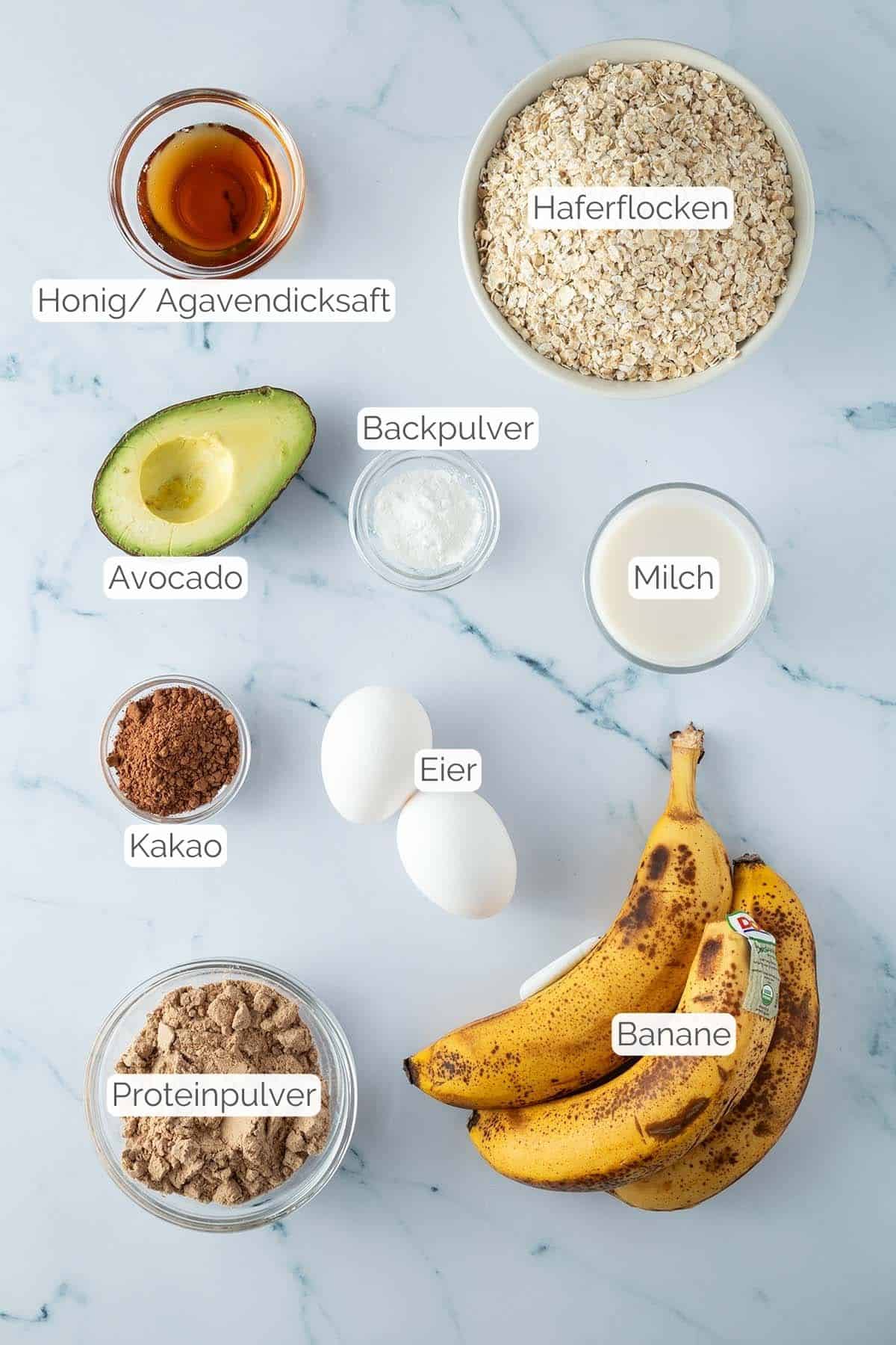 Alle Zutaten mit Textbeschriftungen, die f&uuml;r das Bananen Baked Oatmeal ben&ouml;tigt werden.