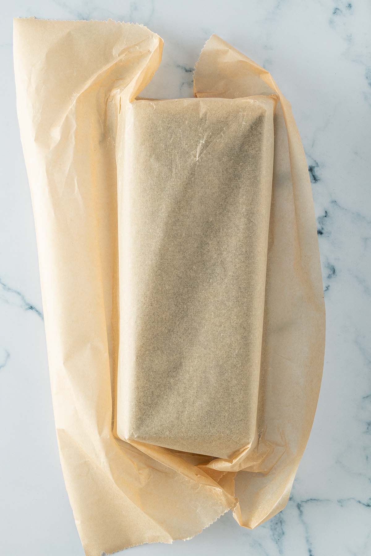 Ein Bogen Backpapier wurde um eine mit der &Ouml;ffnung nach unten liegende Kastenform geschlagen.