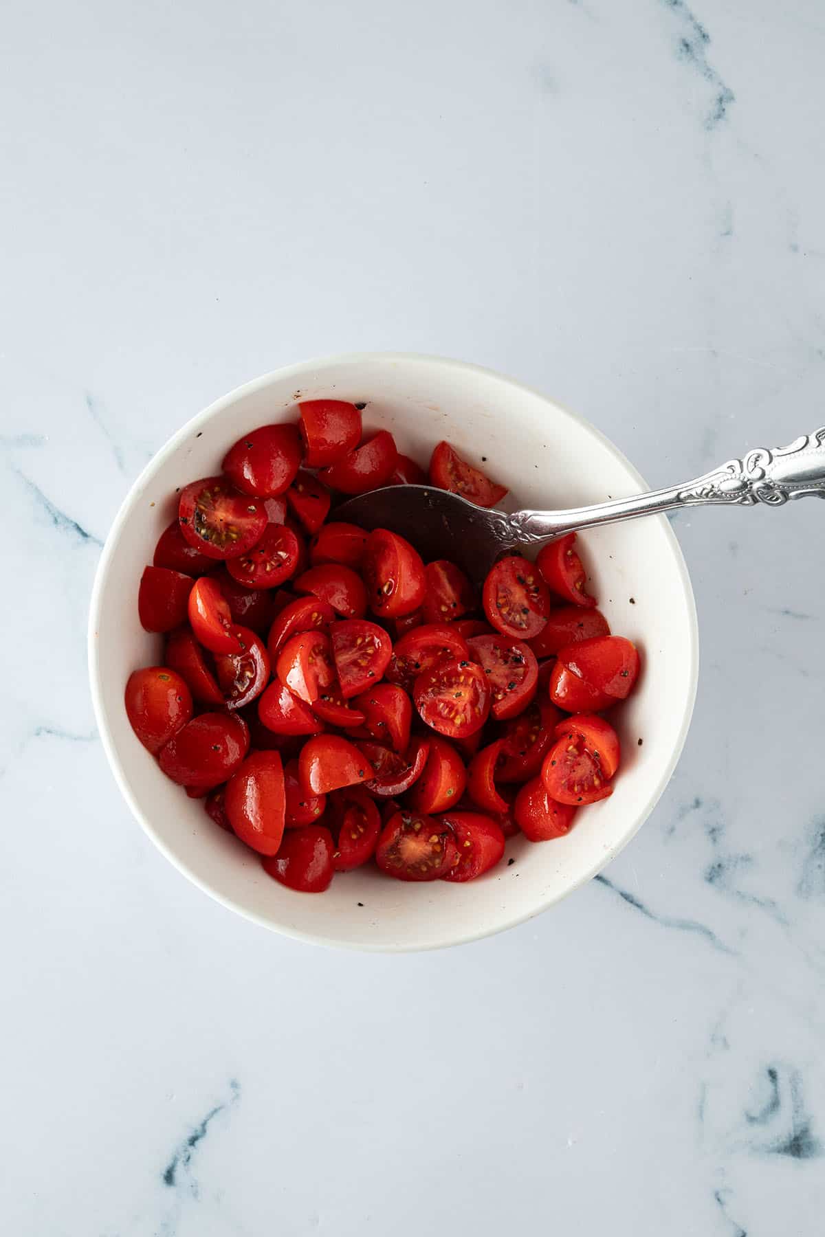 Marinierte Cherrytomaten in einer Sch&uuml;ssel mit Salz und Pfeffer.