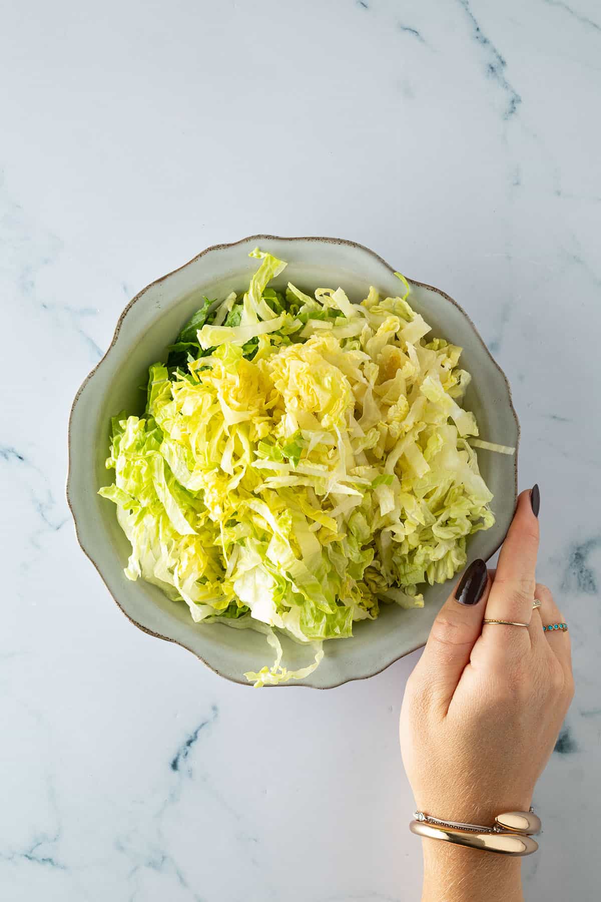 Fein geschnittener Romana-Salat in einer Sch&uuml;ssel f&uuml;r die Burger Bowl.