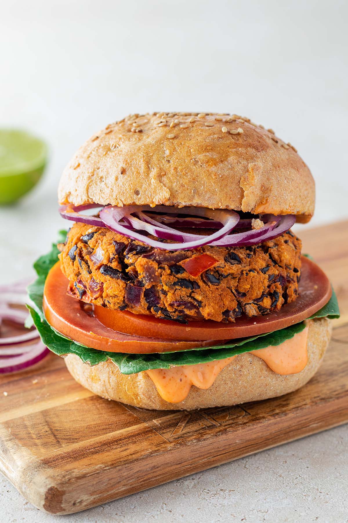 Burger mit einem vegetarischen Bohnen-Patty, frischem Salat, Tomatenscheiben und Zwiebelringen.